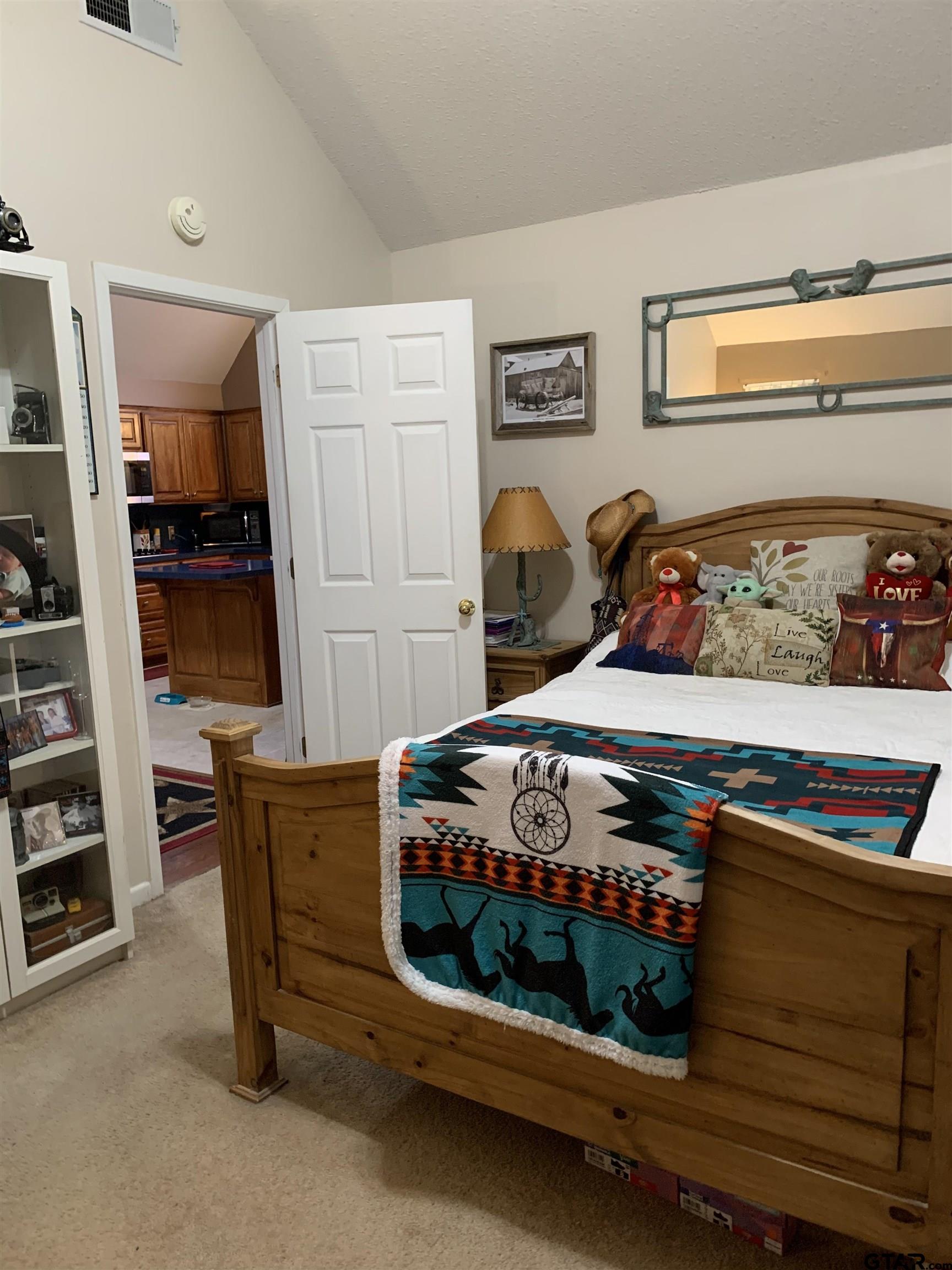 399 Cimarron Trail Holly Lake Ranch, TX 75765 - Photo 19 of 24 a bedroom with bed and a book shelf