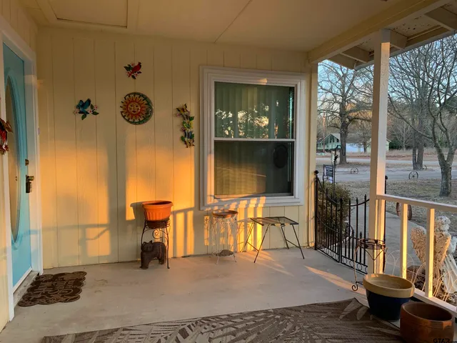 a view of a porch with furniture and floor to ceiling window