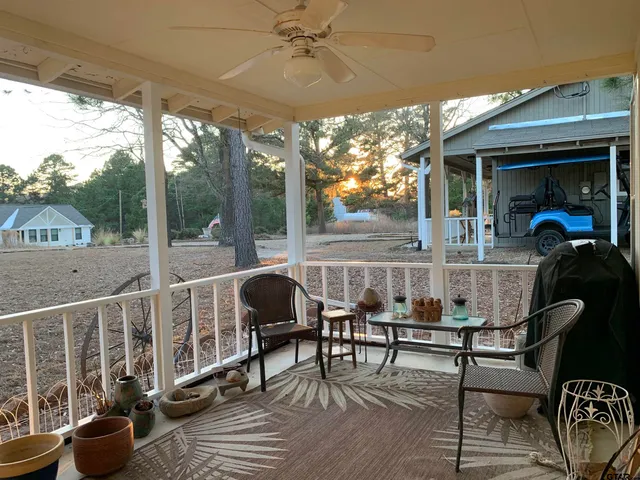 a view of a porch with furniture and a yard