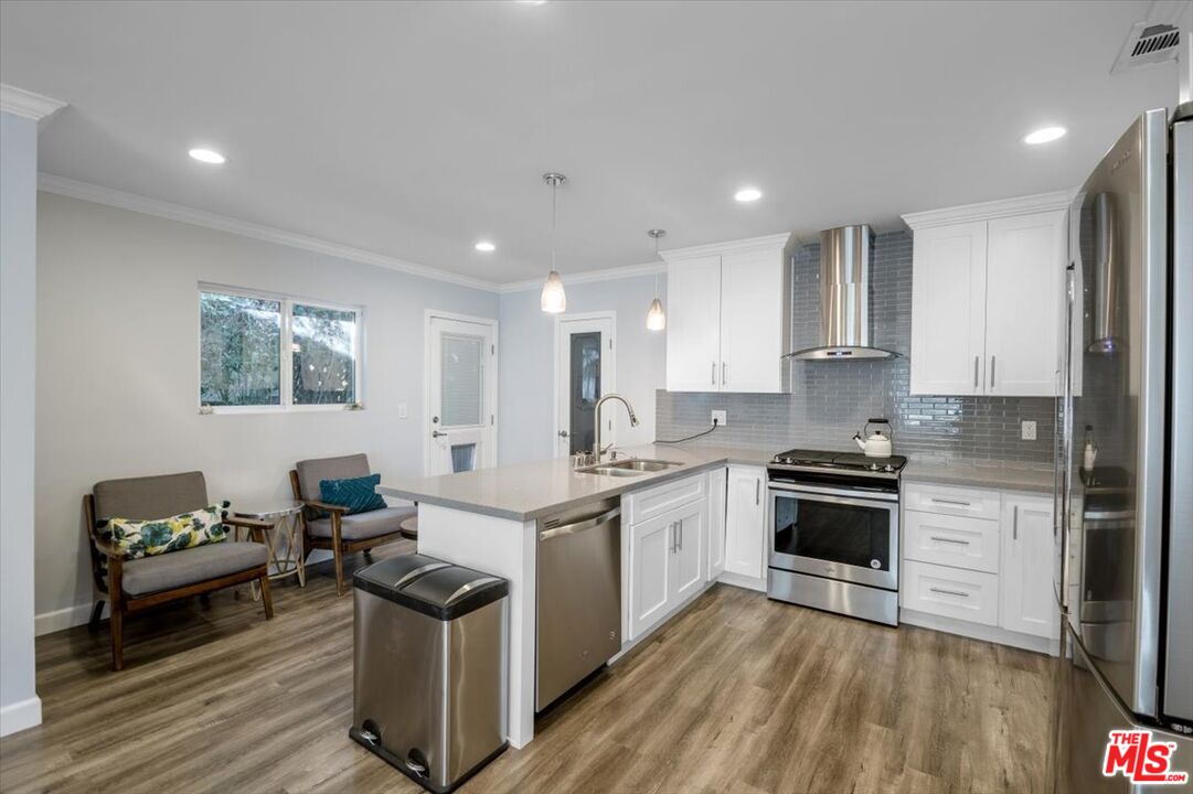 5705 Lemona Avenue Sherman Oaks, CA 91411 - Photo 6 of 30 a kitchen with stainless steel appliances granite countertop a stove top oven a sink dishwasher and a refrigerator
