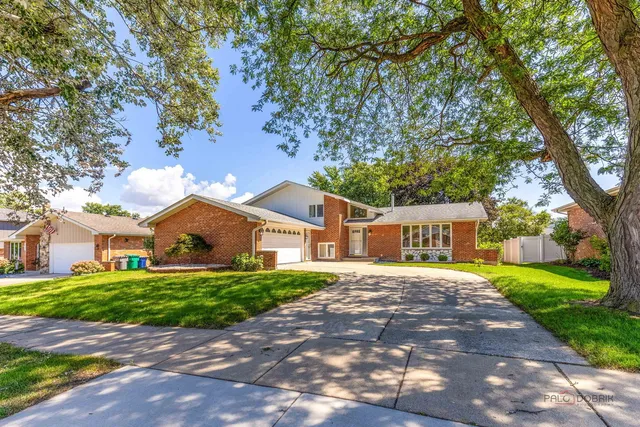 a front view of a house with a yard and trees