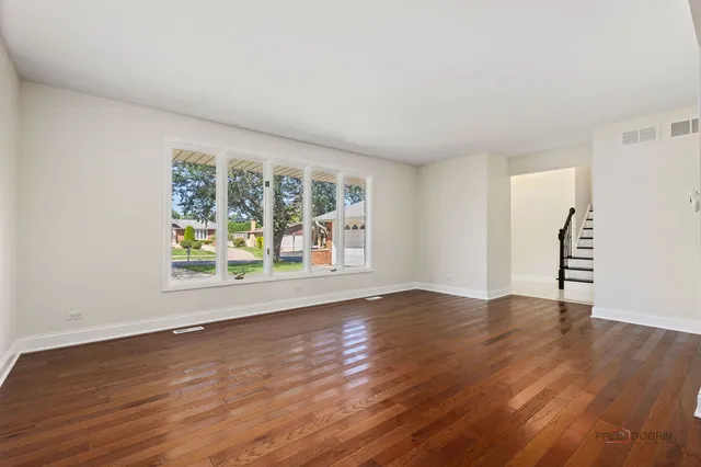 an empty room with a window and a fan