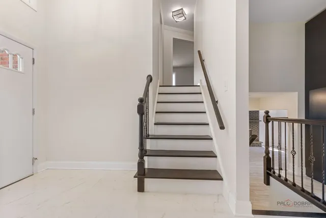 a view of an empty room with wooden floor fireplace and a window