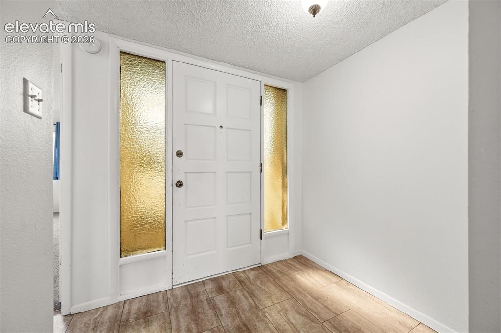 1018 Fontmore Road, Unit A Colorado Springs, CO 80904 - Photo 8 of 28 an empty room with windows and wooden door