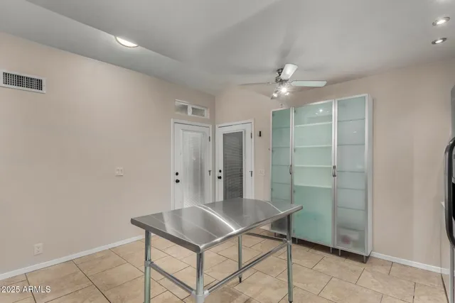a room with chandelier fan and entryway