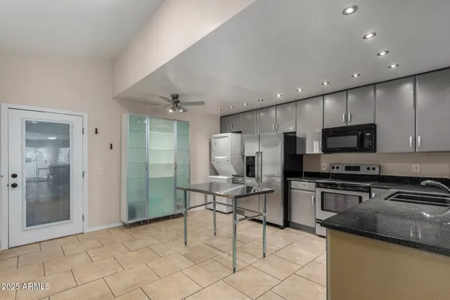 a kitchen with stainless steel appliances granite countertop a refrigerator and a stove top oven