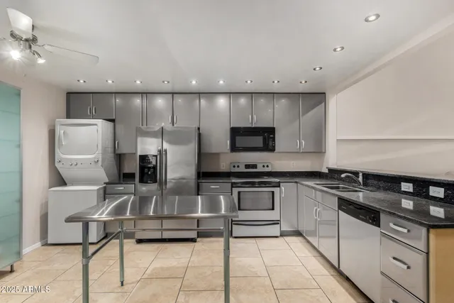 a kitchen with stainless steel appliances kitchen island granite countertop a stove a sink and a microwave