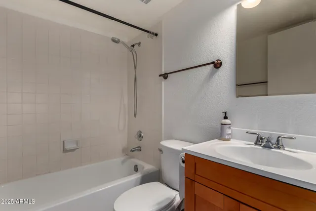 a bathroom with a sink toilet vanity and shower