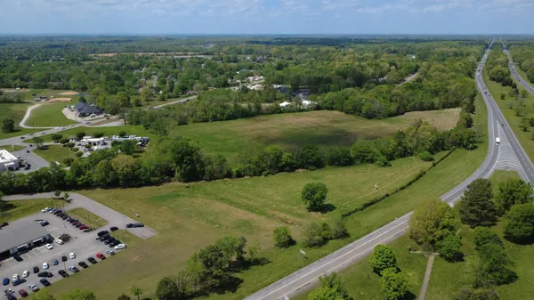 an aerial view of residential houses with outdoor space and trees