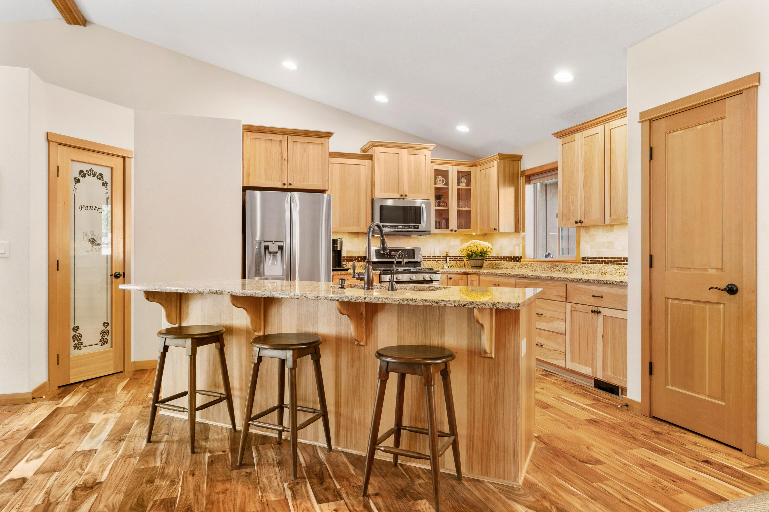 19031 Baker Road Bend, OR 97702 - Photo 6 of 35 a kitchen with kitchen island granite countertop wooden floors and refrigerator
