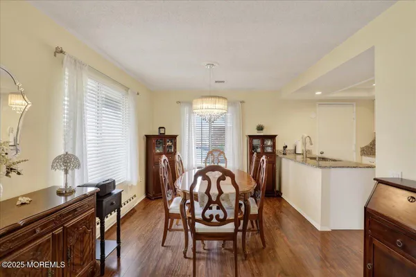 a view of a dining room with furniture a chandelier and wooden floor