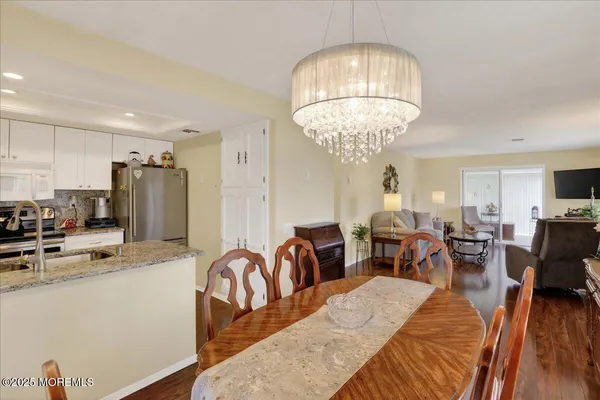 a kitchen with stainless steel appliances granite countertop a refrigerator a sink dishwasher a stove with wooden floors