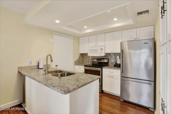 a kitchen with granite countertop a sink and a stove top oven
