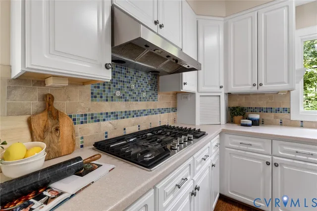 a kitchen with a stove a sink and cabinets