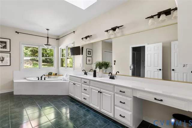 a spacious bathroom with double sink a large mirror and a bathtub next to a window