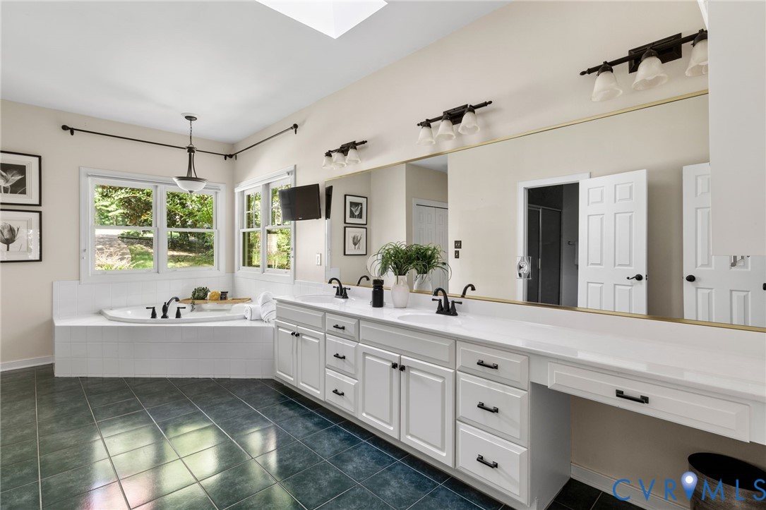 36 Dahlgren Road Richmond, VA 23238 - Photo 27 of 48 a spacious bathroom with double sink a large mirror and a bathtub next to a window