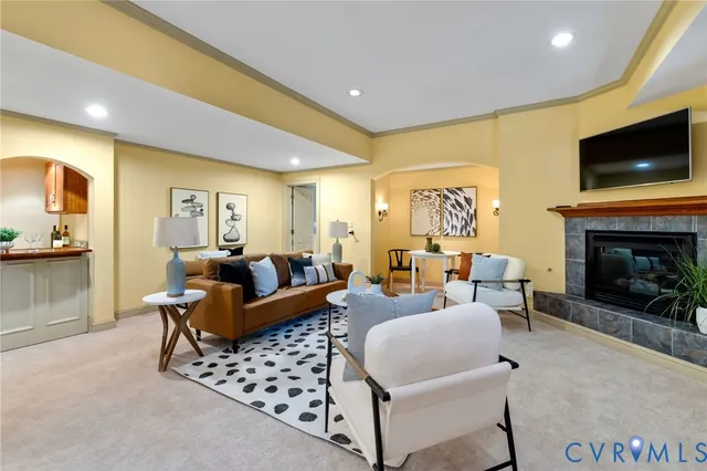 a living room with furniture a flat screen tv and a fireplace