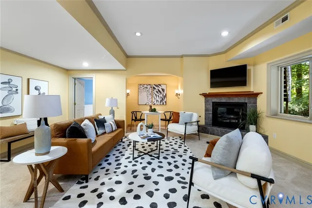 a living room with furniture a flat screen tv and a fireplace