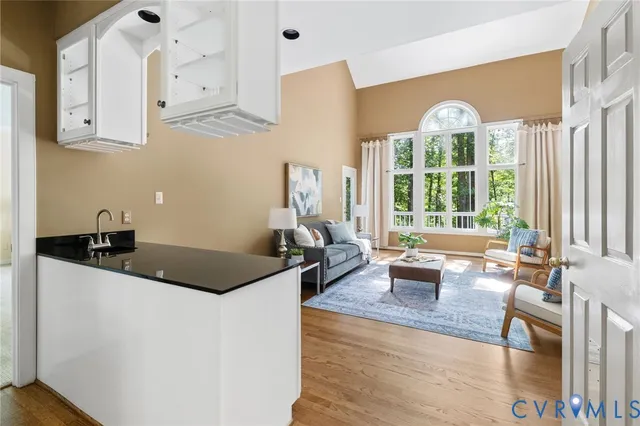 a kitchen with granite countertop a sink a stove and cabinets