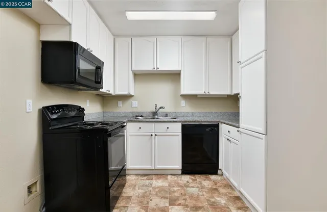 a kitchen with granite countertop a refrigerator stove and microwave