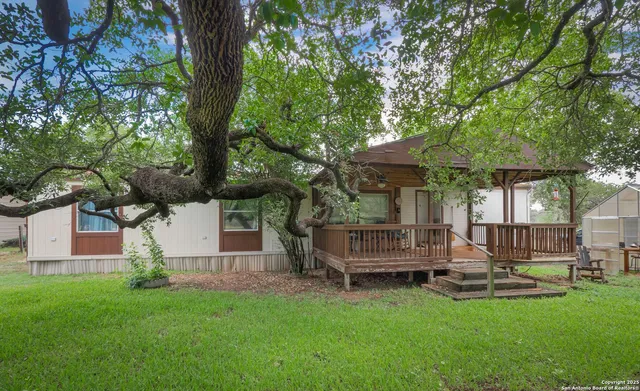 a view of a house with backyard and a tree