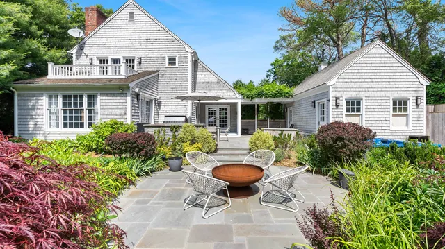 a view of a house with table and chairs in a patio