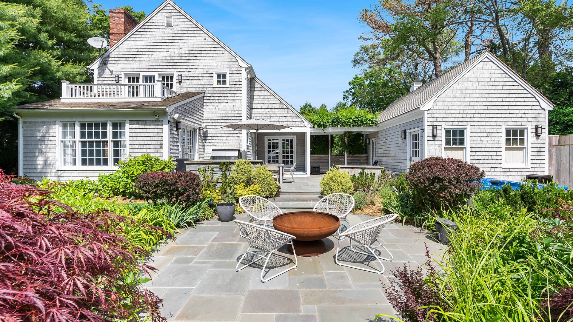 a view of a house with table and chairs in a patio