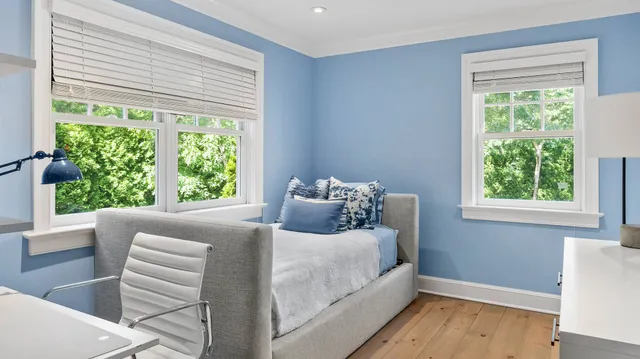 a bedroom with a bed and a large window