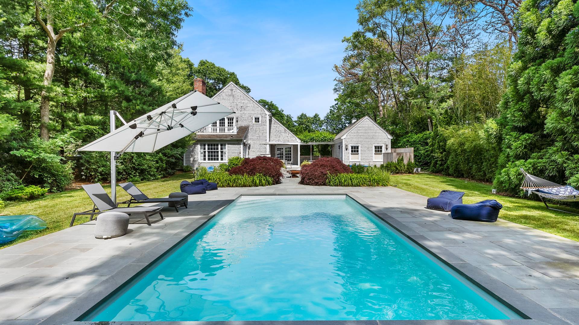 3 Exeter Lane Wainscott, NY 11975 - Photo 2 of 17 a front view of a house with swimming pool garden and patio