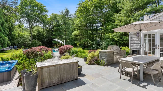 a patio with a table and chairs and potted plants