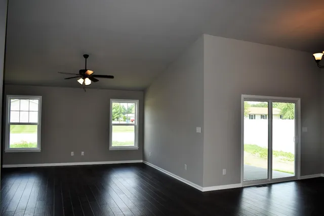 a view of a living room with kitchen and a chandelier fan