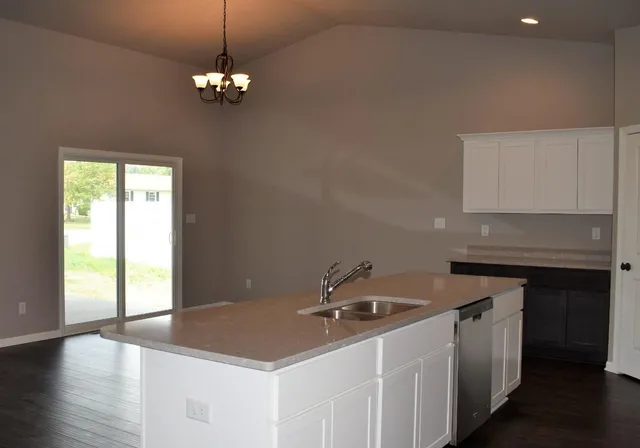 a kitchen with a sink chandelier and refrigerator