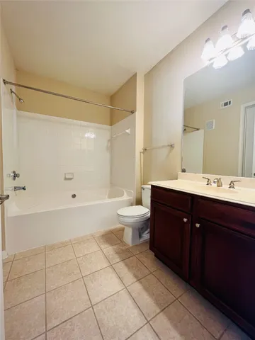 a spacious bathroom with a bathtub shower sink mirror and toilet