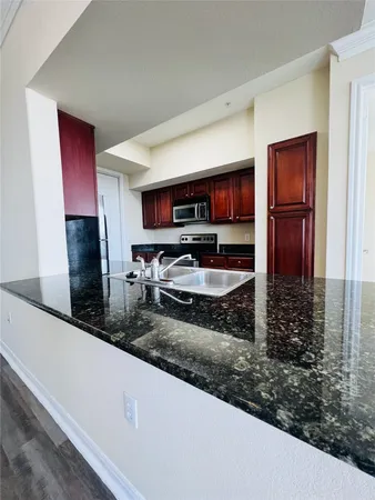 a kitchen with sink a refrigerator and a microwave