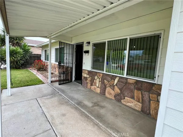a view of a house with a large window and wooden fence