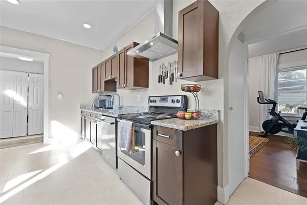 a bedroom with a bed painting on wall and windows