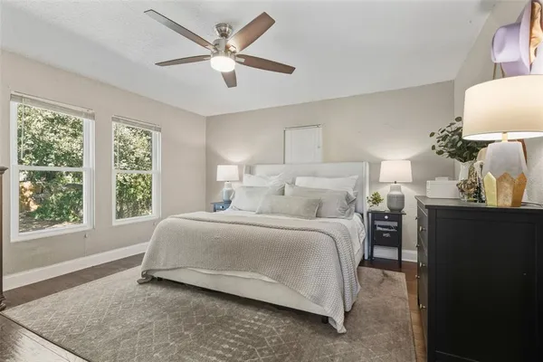 a bedroom with a bed and a large mirror on the dresser