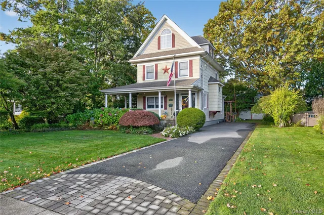a front view of a house with a yard and trees