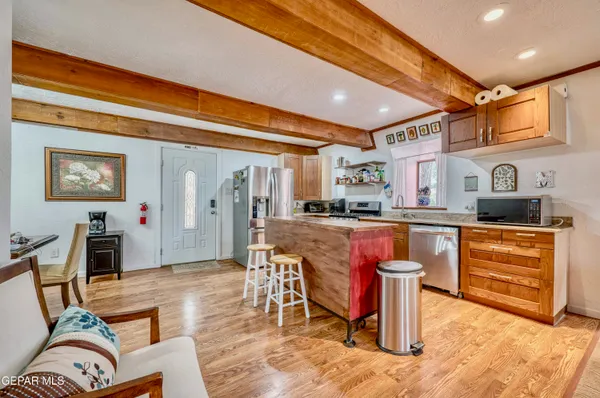 a kitchen with stainless steel appliances kitchen island granite countertop dining table chair and granite counter top