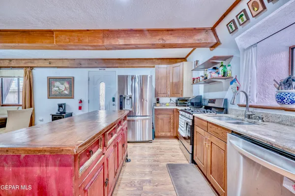 a kitchen with stainless steel appliances granite countertop a stove a sink and a refrigerator