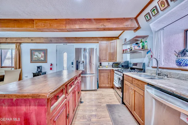 a kitchen with stainless steel appliances granite countertop a stove a sink and a refrigerator