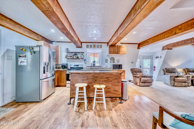 a kitchen with stainless steel appliances granite countertop a stove a sink and a refrigerator