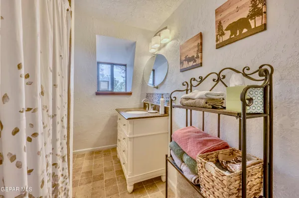 a bathroom with a granite countertop sink and a mirror