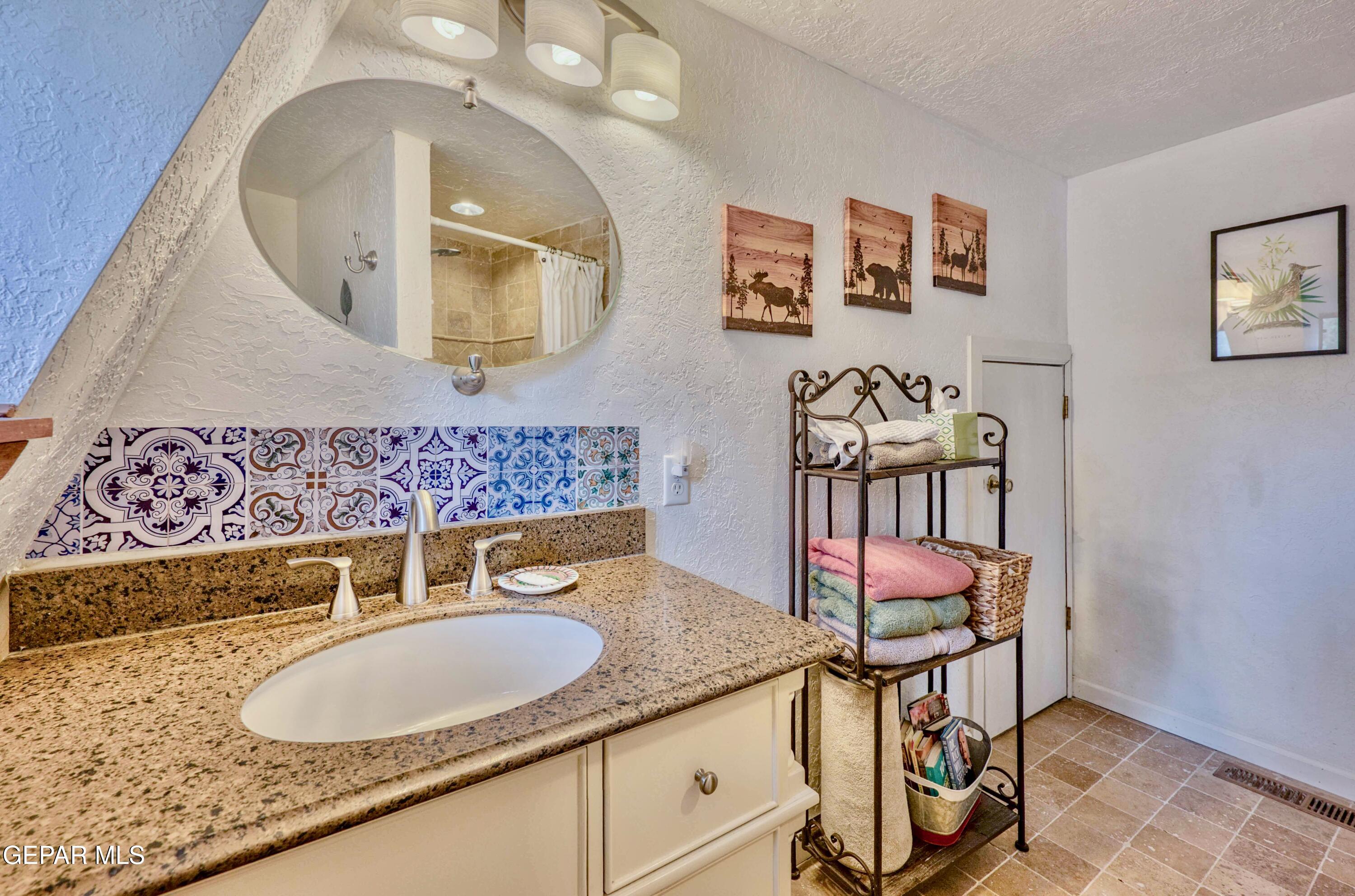 104 Meadow Wood Ruidoso, NM 88345 - Photo 35 of 55 a bathroom with a granite countertop sink and a mirror