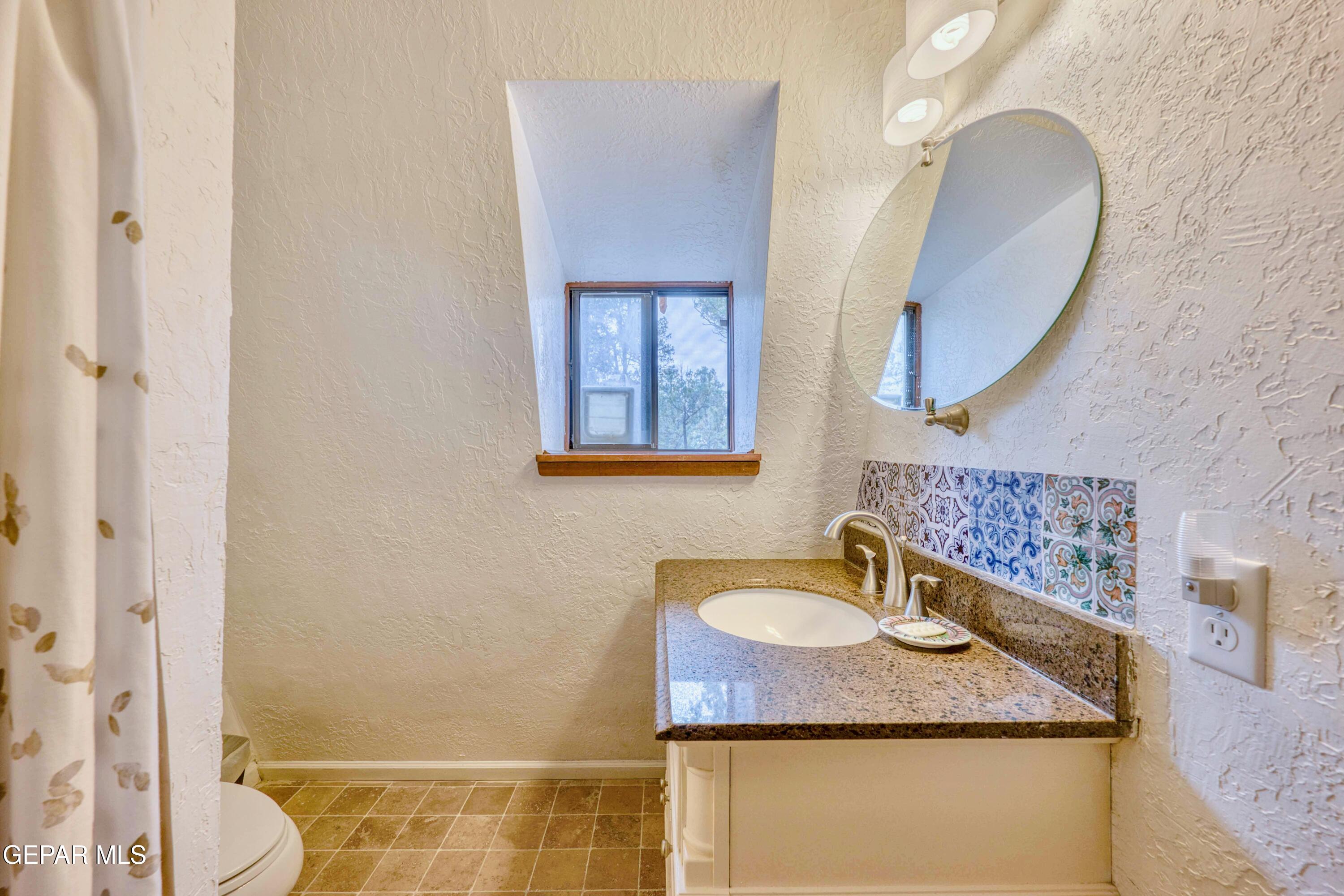 104 Meadow Wood Ruidoso, NM 88345 - Photo 38 of 55 a bathroom with a granite countertop sink and a mirror