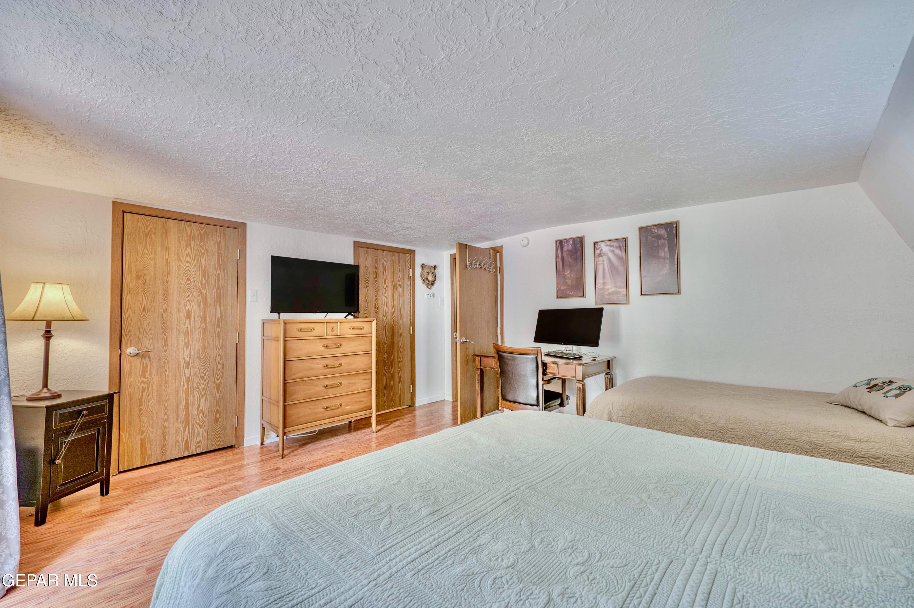 104 Meadow Wood Ruidoso, NM 88345 - Photo 46 of 55 a bedroom with a bed and a flat screen tv