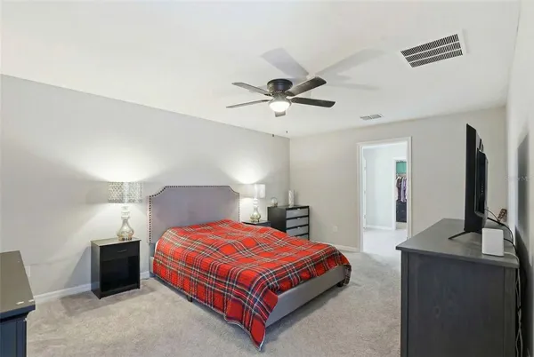 a bedroom with a large bed and a flat tv screen on dresser