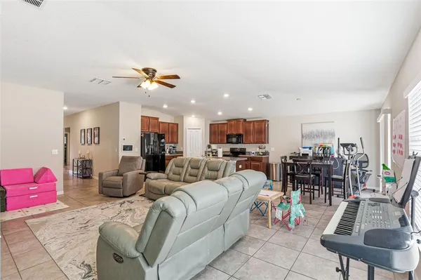 a living room with furniture kitchen view and a flat screen tv