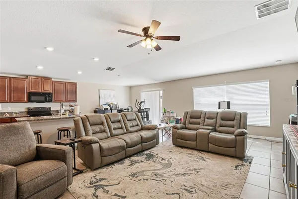 a living room with furniture and a view of kitchen