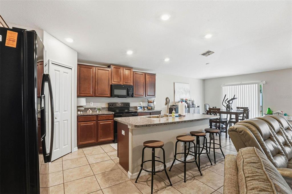 211 English Channel Place Dover, FL 33527 - Photo 24 of 35 a kitchen with stainless steel appliances granite countertop a stove a refrigerator a sink a stove a dining table and chairs
